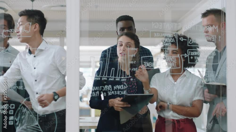 group of business people brainstorming writing ideas on glass whiteboard colleagues working on problem solving solution discussing strategy teamwork in office meeting 4k