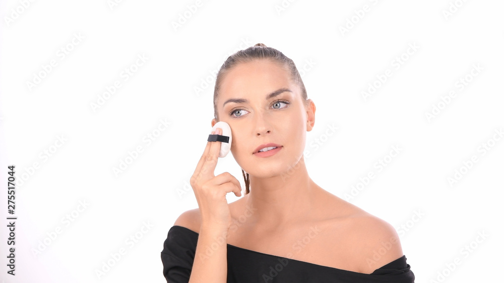 Beauty concept. Young woman applying blusher on her face with powder puff. Beauty concept. Young woman applying blusher on her face with powder puff.