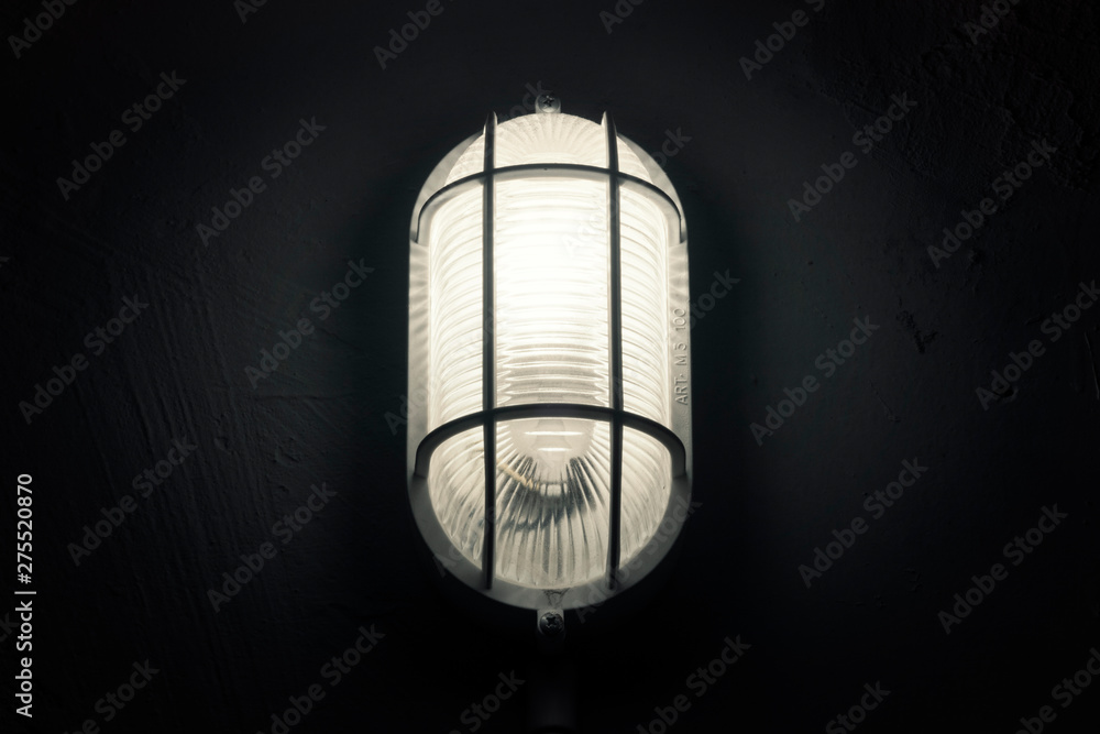 An ominous, scary lamp in a basement. Cold light. Close-up shot.