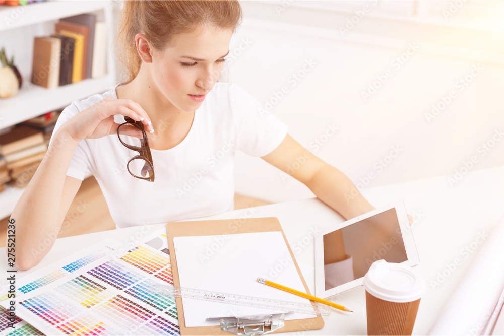 Young female designer with tablet at workplace Young female designer with tablet at workplace