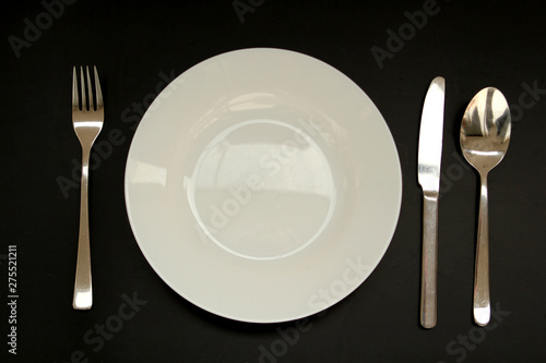 cutlery next to an empty white plate, copy space