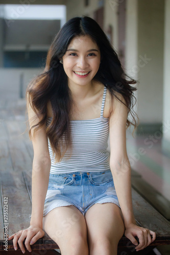 Portrait of thai adult beautiful girl White shirt blue jeans relax time