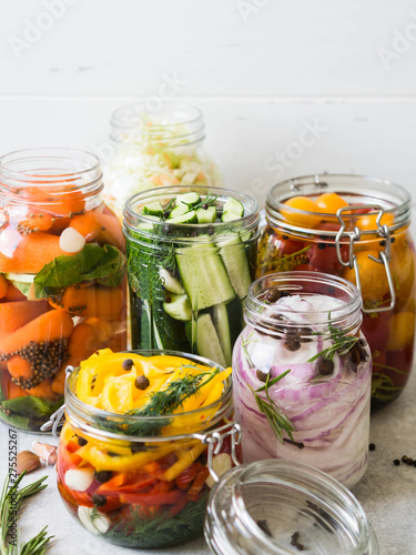 Pickled vegetables. Salting various vegetables in glass jars for long-term storage. Preserves vegetables in glass jars. Variety fermented green vegetables on table.