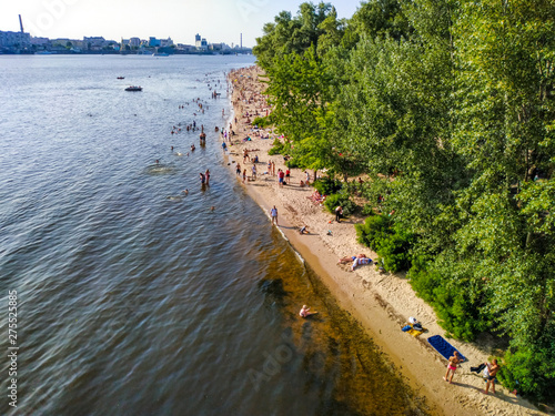 People rest on the banks of the Dnipro River in recreation area of Trukhaniv Island, Kiev, Ukraine photo