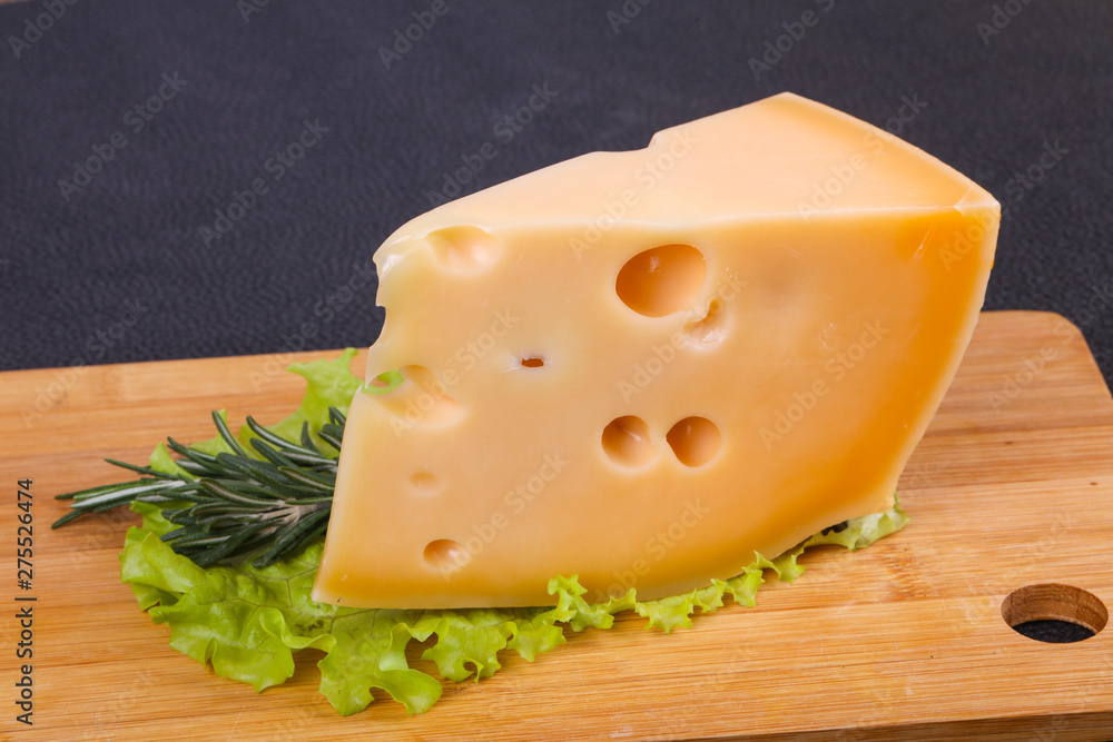 Maasdam cheese in the board served salad leaves Maasdam cheese in the board served salad leaves