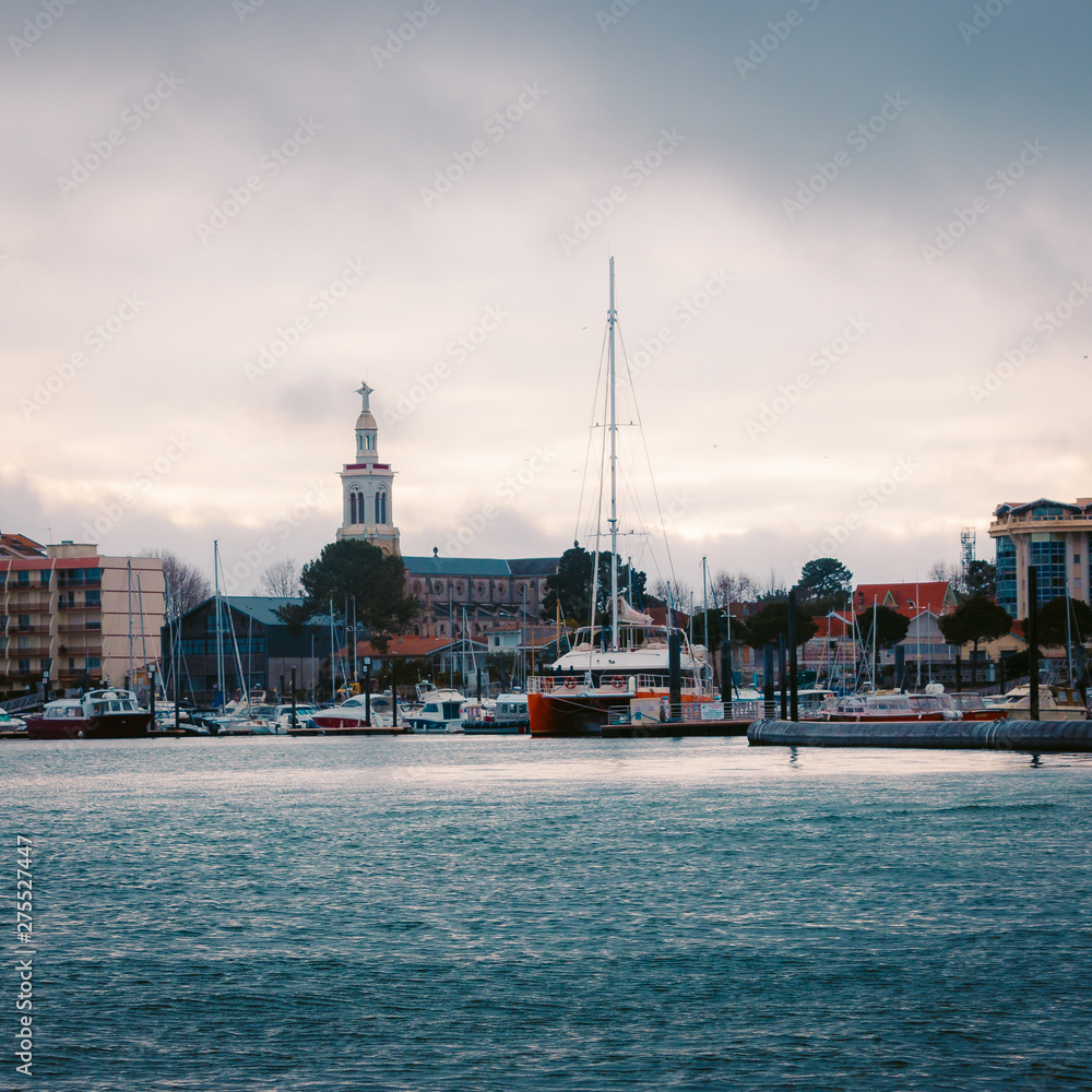 Naklejka premium View of the harbor of Arcachon from the see. The Saint-Ferdinand church dominate the city.