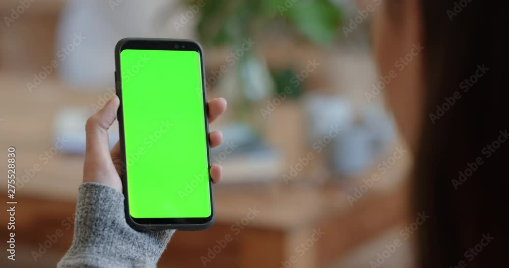 woman using smartphone green screen having video chat waving at friend on chroma key enjoying mobile phone communication display in vertical orientation 4k woman using smartphone green screen having video chat waving at friend on chroma key enjoying mobile phone communication display in vertical orientation 4k