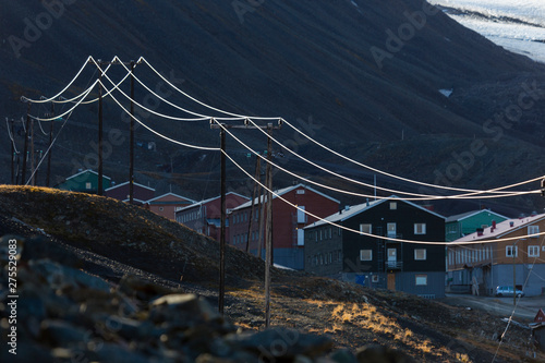 overview of longyearbyen, colored houses, power line with mountains in the background, svalbard, norway photo