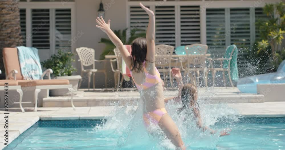 happy kids jumping in swimming pool friends splashing playfully having fun together on sunny day enjoying cool water on summer vacation at holiday home 4k