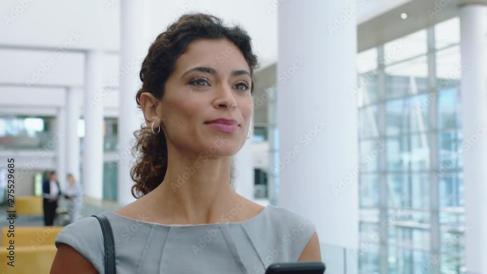hispanic business woman using smartphone texting walking in corporate ...