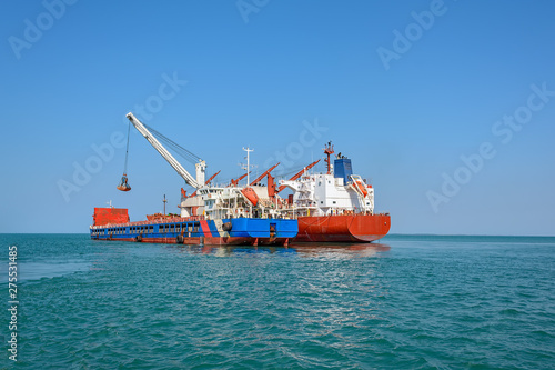 Loading ocean-going bulk carrier ship with Bauxite aluminum ore from the mini bulk carrier (feeder) vessel at offshore Kamsar port, Guinea, West Africa. © Igor Groshev