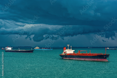 Oil/Chemical tankers anchored on outer anchorage in the Strait of Singapore under the stormy clouds.