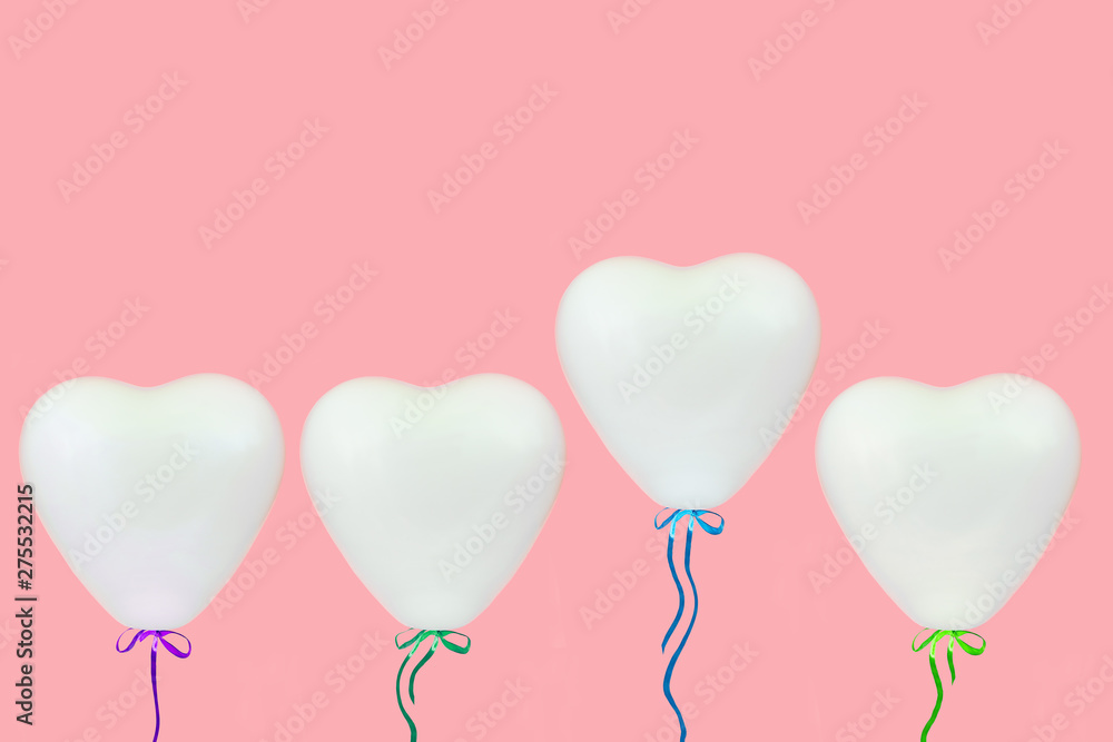 holidays, valentines day and party decoration concept - white heart shaped balloons over pastel coral pink background