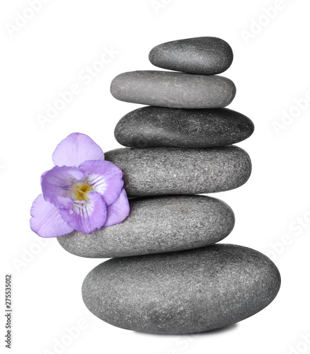 Stack of grey spa stones and fresh flower isolated on white