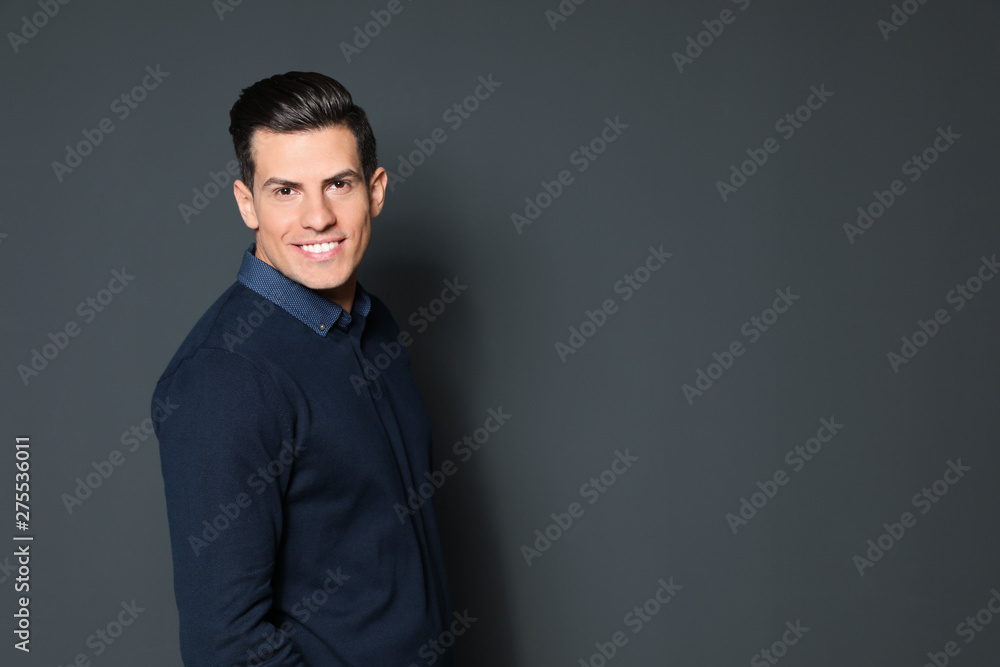 Portrait of handsome man smiling on grey background. Space for text