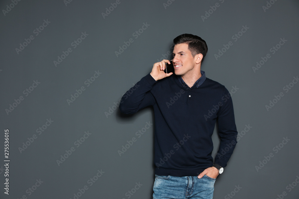 Portrait of handsome man talking on phone against grey background. Space for text Portrait of handsome man talking on phone against grey background. Space for text