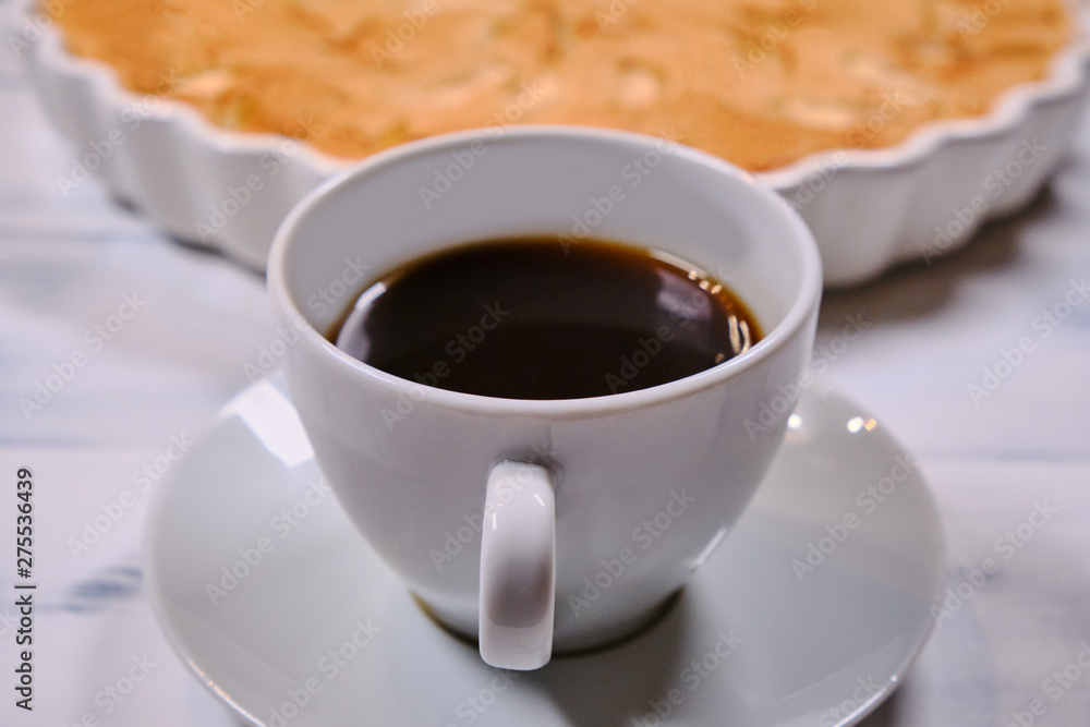 Apple pie and cup of coffee on a white background. Homemade cakes of ripe apples. Fruit cake in a white wooden background. Apple pie and cup of coffee on a white background. Homemade cakes of ripe apples. Fruit cake in a white wooden background.