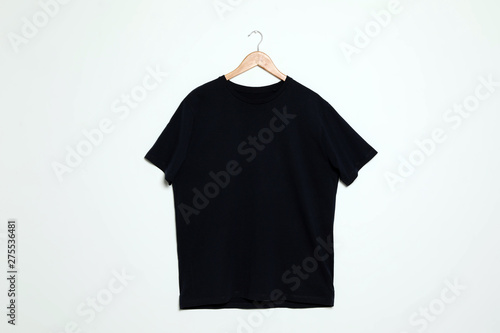Hanger with blank t-shirt on white background. Mock up for design