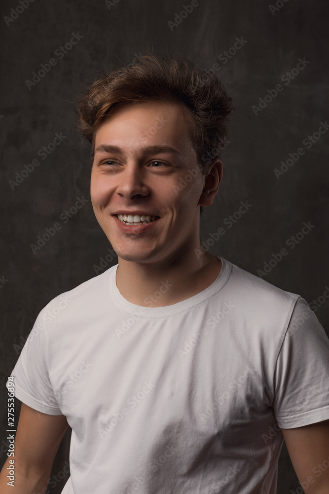 Handsome young man on black background looking at camera.