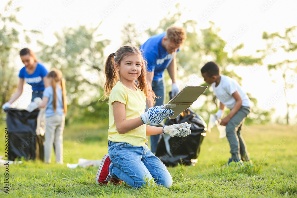 Little girl collecting trash in park. Volunteer project Little girl collecting trash in park. Volunteer project