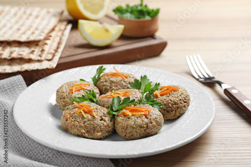 Plate of traditional Passover (Pesach) gefilte fish on wooden background