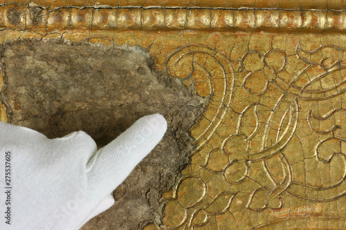 Restoration: gold restoration, old icon. close up. conservation of paintings. conservation of sculptures photo