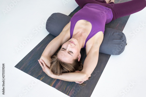 Foto European slim woman practicing yoga lying in Reclined Butterfly exercise relaxin
