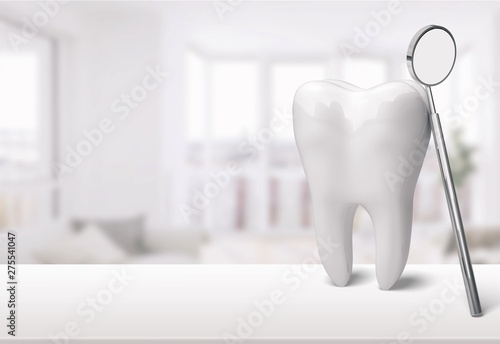White tooth and dentist mirror on white desk