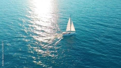 Sailboat in the ocean. White sailing yacht in the middle of the boundless ocean. Aerial view.