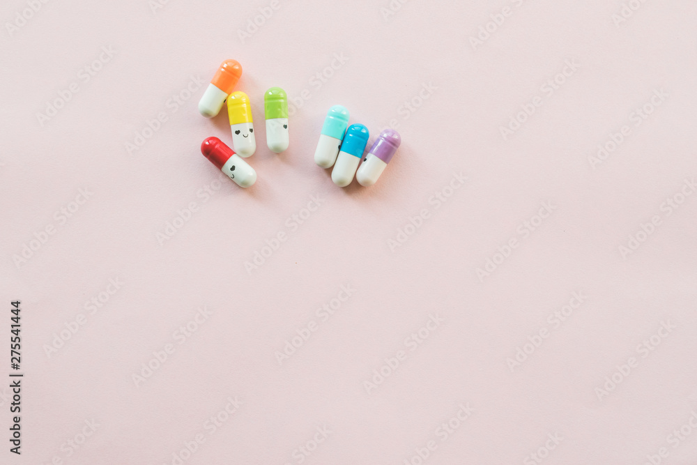 Funny multicolored capsule on a pastel paper pink background. Copyspace Funny multicolored capsule on a pastel paper pink background. Copyspace