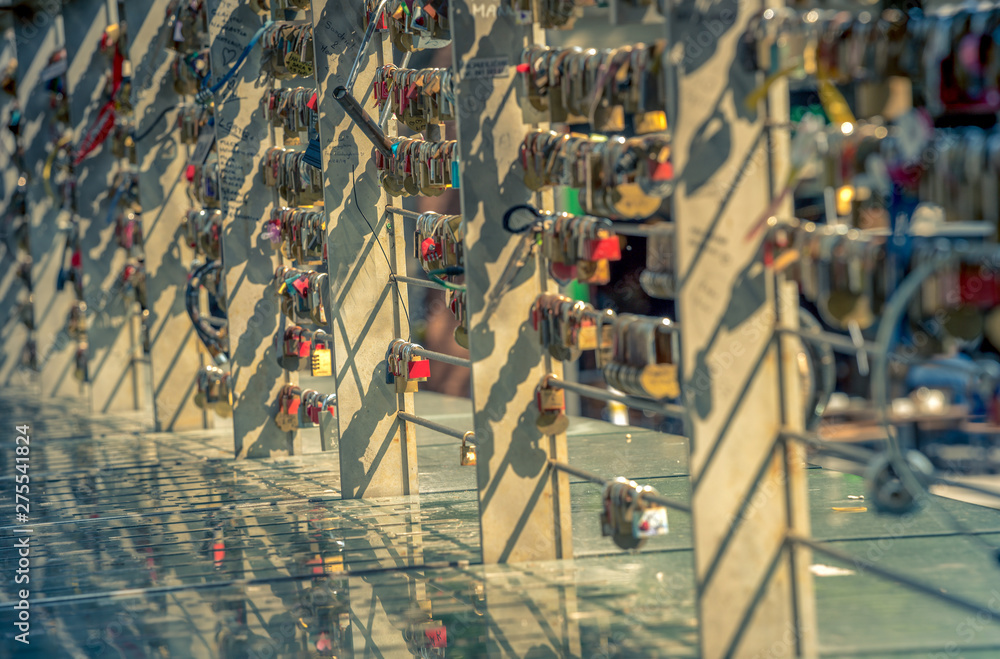 Obraz premium locks with a heart and a lot of other locks on the bridge with reflection
