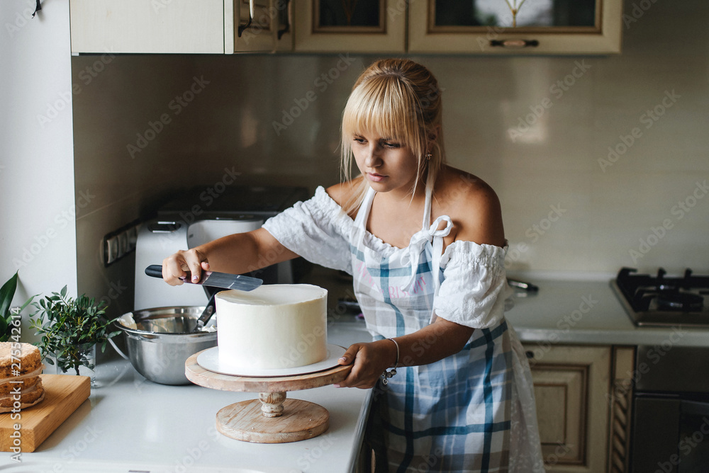Attractive young woman is cooking on kitchen. Having fun while making cakes and cookies. Attractive young woman is cooking on kitchen. Having fun while making cakes and cookies.