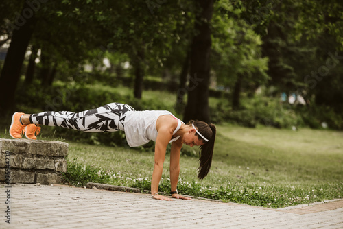  A beautiful fitness girl trains in the park. Nature and healthy life