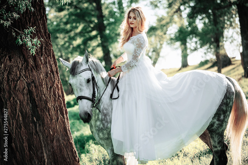Beautiful and stunning bride, riding a horse in the nature
