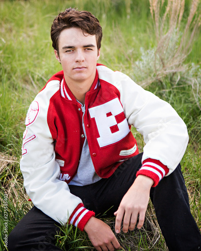 High school senior male posing in his letter jacket.  © julie