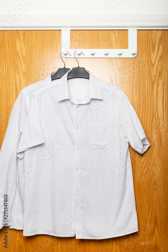 Back to school concept, school uniform such as white shirts hanging on the door