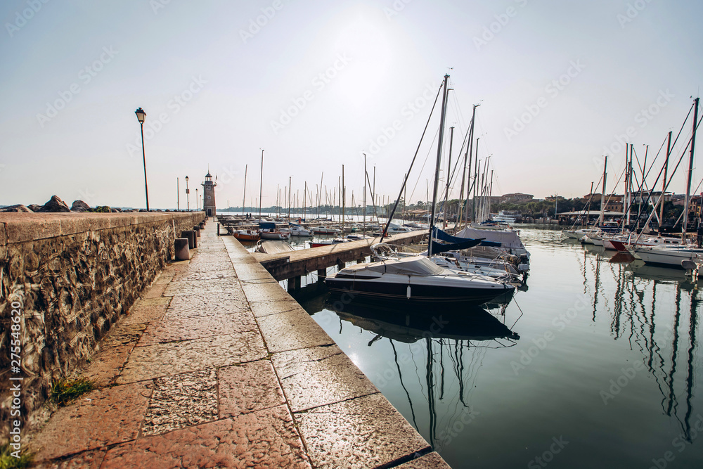 Fototapeta premium old harbour full of boats in Desenzano del Garda. Brescia, Lombardy, Italy. City Centre of Desenzano del Garda. marina on Lake Garda.