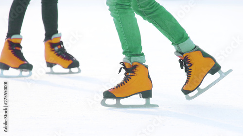 feet in red skates on an ice rink. Hobbies and sports during the winter holidays