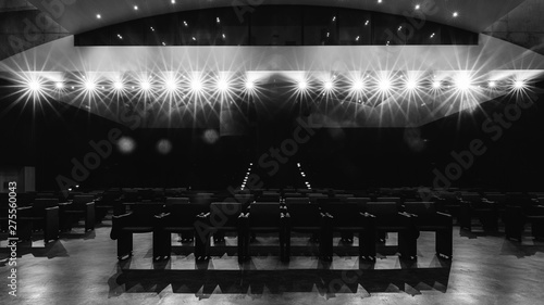 View towards empty audience seats at from stage with deliberate spotlights - monochrome