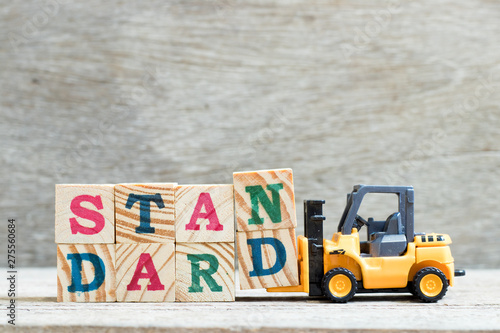 Toy forklift hold letter block n, d to complete word standard on wood background photo