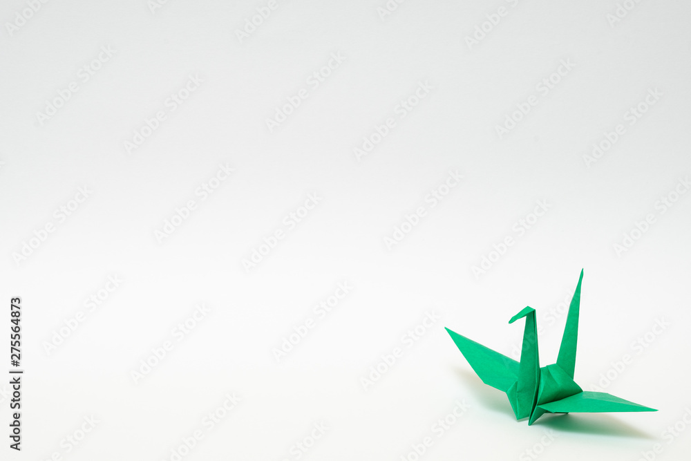green origami paper crane on white background green origami paper crane on white background