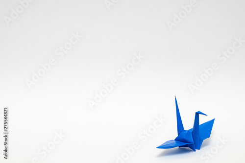blue origami paper crane on white background