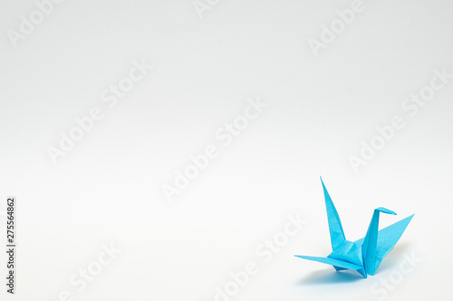 light blue origami paper crane on white background