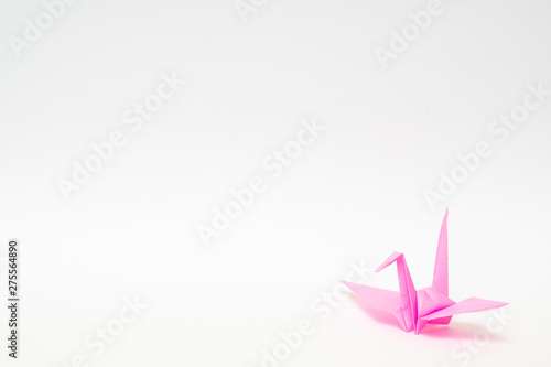 pink origami paper crane on white background