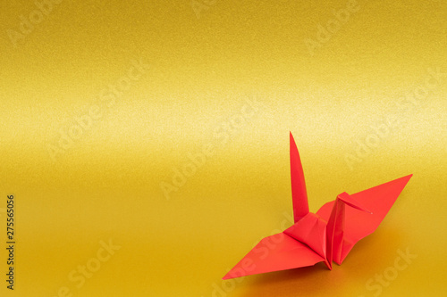 red origami paper crane on golden background