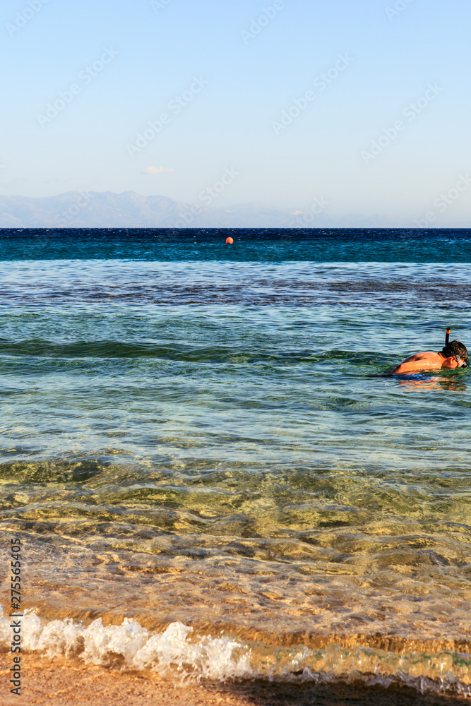 A child enjoying snorkeling in the clear sea. A child enjoying snorkeling in the clear sea.