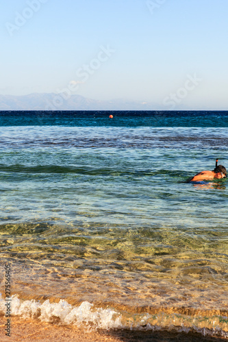 Fototapeta Naklejka Na Ścianę i Meble -  A child enjoying snorkeling in the clear sea.