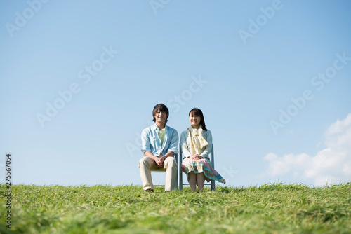 草原で椅子に座るカップル