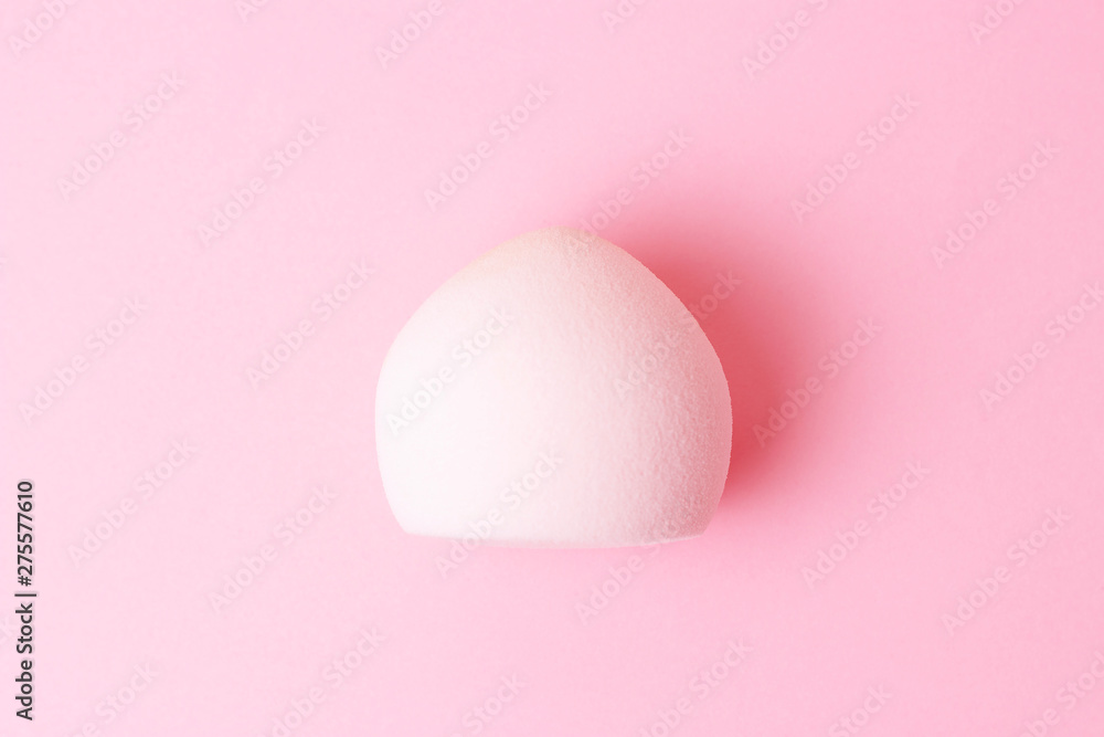 Makeup sponge isolated on pink background close-up, top view.