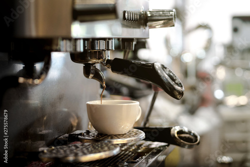 Barista using espresso machine making coffee in the coffee shop